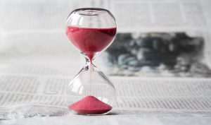 prescribed rate loans set to rise concept as an hourglass with red sand on newspaper